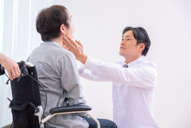 歯の状態を確認してもらう車いすの高齢女性